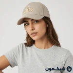 مدل زن با کلاه بیسبالی Alo کرم، استایل کژوال با لوگوی طلایی