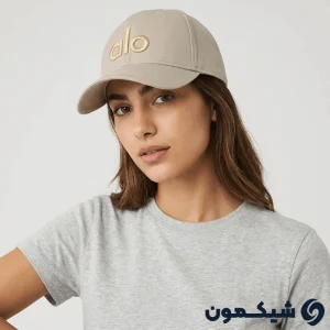 مدل زن با کلاه بیسبالی Alo کرم، استایل کژوال با لوگوی طلایی