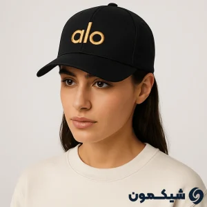مدل زن با کلاه بیسبالی Alo مشکی با لوگوی طلایی، نمای نیم‌رخ