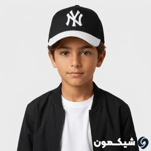 پسربچه‌ای با کاپشن خلبانی مشکی که کلاه بچگانه NY پشت تور مشکی با نقاب سفید را بر سر دارد
